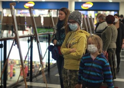 skupina lidí s maskami na letišti.