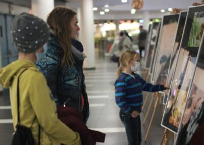 skupina lidí stojících kolem bílé tabule.