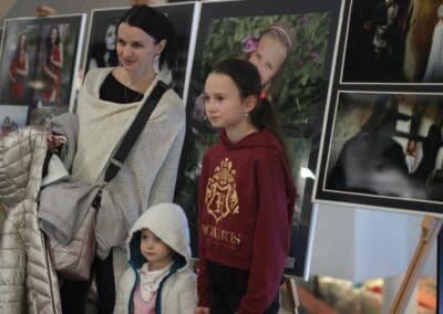 žena a dvě děti stojící před obrázky.