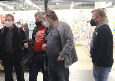 skupina lidí s maskami v obchodě.