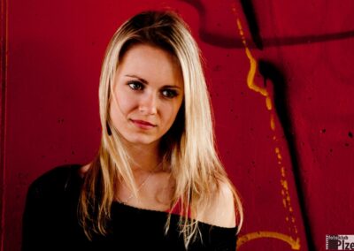 žena stojící před červenou zdí.