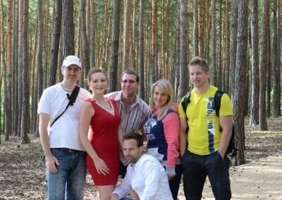 skupina lidí pózujících pro obrázek v lese.