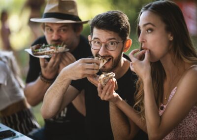 skupina lidí sedících kolem stolu a jedí pizzu.