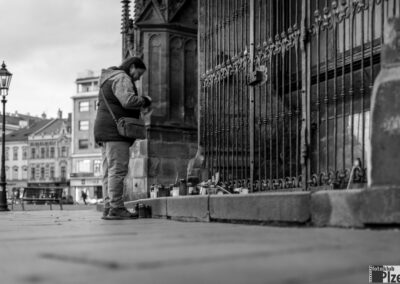 černobílá fotografie muže stojícího před bránou.