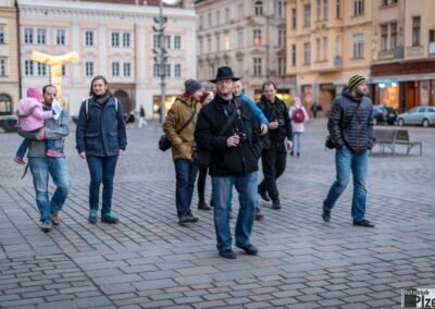 skupina lidí, kteří jdou po ulici vedle vysokých budov.