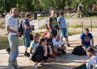 skupina lidí sedících na dřevěném doku.