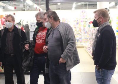 skupina lidí s maskami v obchodě.