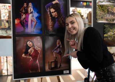 Žena pózuje před výstavou fotografií.