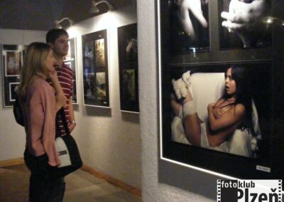 muž a žena se dívají na obrázky na zdi.